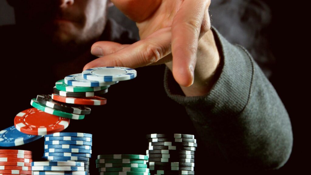 Muškarac baca šarene žetone u vazduh iznad uredno pore?anih gomila