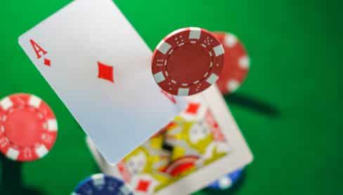 As karo i crveni ?ip u vazduhu iznad karata i ?ipova na stolu.