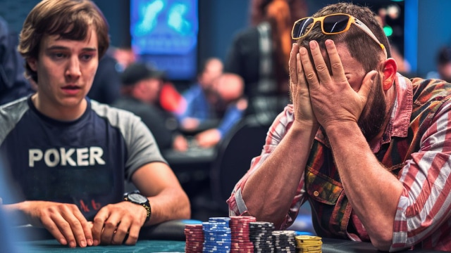 Igra? pokriva lice rukama u znaku frustracije, dok drugi mladi? posmatra situaciju za poker stolom