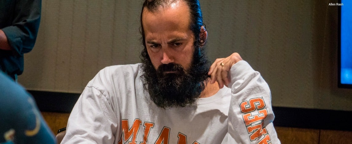 Jason Mercier sentado em uma mesa de poker analisando sua jogada e fazendo uma cara de pensativo